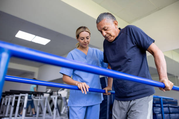 Physiotherapist supporting an older man during walking rehabilitation